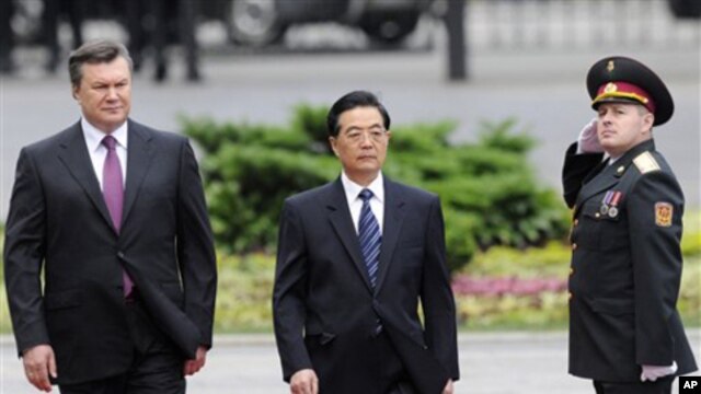 Ukrainian President Viktor Yanukovich (l) and Chinese President Hu Jintao review the honor guard in Kyiv, June 20, 2011