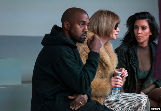 FILE - Singer Kanye West watches models rehearse while sitting with his wife Kim Kardashian (R) and Anna Wintour before presenting his Fall/Winter 2015 partnership with Adidas at New York Fashion Week .