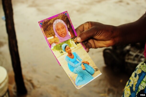 FILE - Esther Yakubu holds a photo of her daughter Dorcas, who was featured in a Boko Haram video released in August.