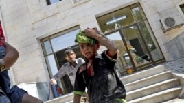 Wounded Syrians evacuate a field hospital after a second air strike in Azaz on the outskirts of Aleppo, Syria, August 15, 2012.