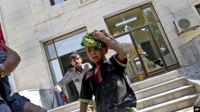 Wounded Syrians evacuate a field hospital after a second air strike in Azaz on the outskirts of Aleppo, Syria, August 15, 2012.