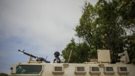 A Ugandan police officer serving with the African Union Mission in Somalia's first Formed Police Unit stands at the top of an armored personnel carrier at a police station in the capital Mogadishu, August 7, 2012.