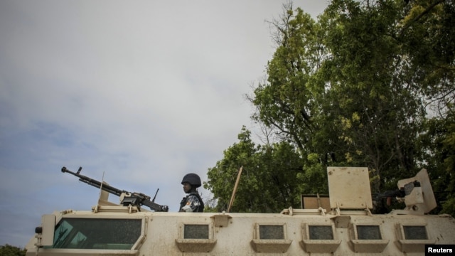 A Ugandan police officer serving with the African Union Mission in Somalia's first Formed Police Unit stands at the top of an armored personnel carrier at a police station in the capital Mogadishu, August 7, 2012.