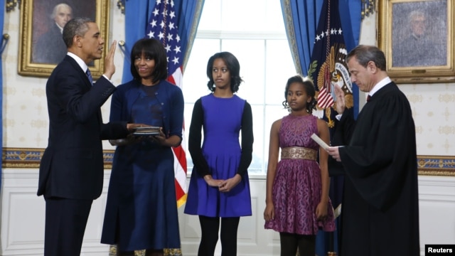 Presiden AS Barack Obama (kiri) saat diambil sumpahnya oleh Ketua Mahkamah Agung AS John Roberts disaksikan oleh ibu negara Michelle Obama dan kedua puterinya, Malia dan Sasha di Gedung Putih hari Minggu (20/1). 