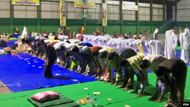 Anggota Syiah dari Sampang, Madura, Jawa Timur, shalat berjamaah di tempat pengungsian dalam gedung olahraga. (VOA/Petrus Riski)