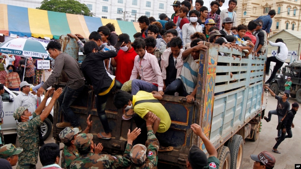 Cambodian migrant workers get off from a Thai truck upon their arrival from Thailand at a Cambodia-Thai international border gate in Poipet, Cambodia, Tuesday, June 17, 2014. 
