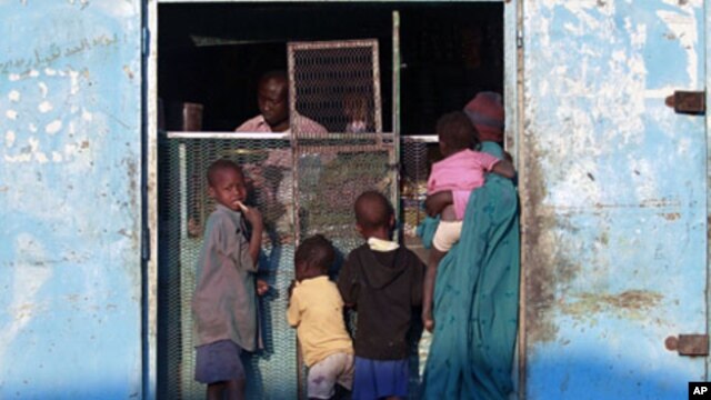 A south Sudanese woman gets supplies from a Nuba shop, 11 Jan 2011