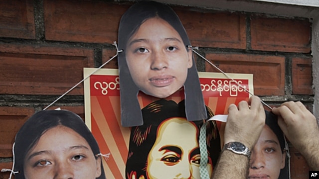 A Myanmar activist puts cutouts of imprisoned Hla Hla Win, a reporter of the Norway-based Democratic Voice of Burma, on a wall near Myanmar Embassy during a rally in Bangkok, Thailand, (File September 9, 2011).