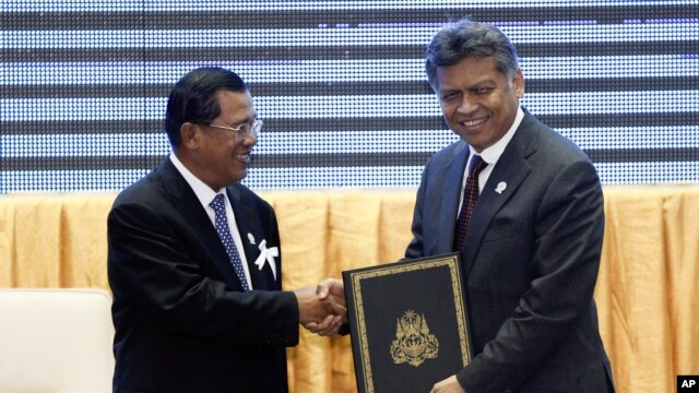 Cambodia's PM Hun Sen, left, with ASEAN Secretary-General Surin Pitsuwan after the ceremony for the adoption of the ASEAN Human Rights Declaration,  during the ASEAN Summit in Phnom Penh, November 18, 2012. 
