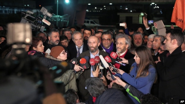 Can Dundar, the editor-in-chief of opposition newspaper Cumhuriyet, center right, and Erdem Gul, the paper's Ankara representative, center left, speak to the media outside Silivri prison near Istanbul, after their release early Friday, Feb. 26, 2016.