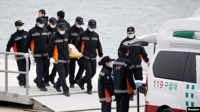 Nhân viên dịch vụ khẩn cấp mang thi thể nạn nhân từ chiếc phà bị chìm lên xe cứu thương tại cảng Jindo, ngày 22/4/2014.