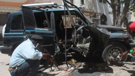 Polisi wa Somalia akiangalia mabaki ya mlipuko wa gari lililopigwa bomu huko Mogadishu, Somalia, Jumatatu, April, 21, 2014.