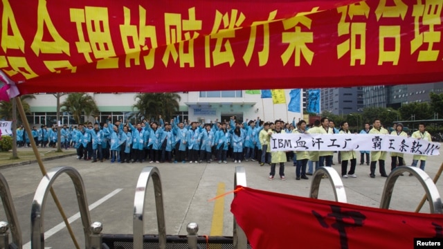 Công nhân xuống đường trong một vụ đình công ở tỉnh Quảng Đông, Trung Quốc hồi tháng 3/2014. Trong năm 2014 đã có gần 1.400 vụ đình công, và con số những vụ phản kháng đã tăng với tốc độ cao hơn nữa trong hai tháng đầu của năm 2015.