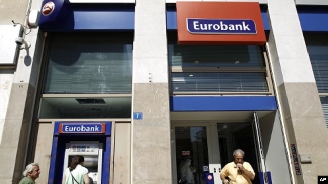 A woman makes a transaction at an ATM of a Eurobank branch in Athens September 23, 2011.