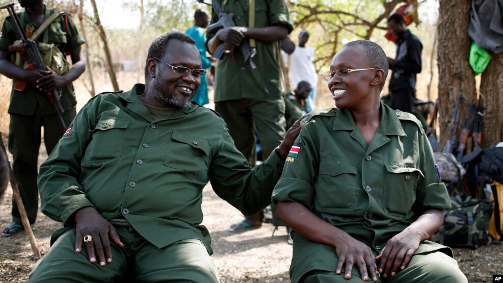 FILE - South Sudan's rebel leader Riek Machar (L) and his wife Angelina Teny joke in front of their tent in a rebel-controlled area in Jonglei State, South Sudan, Jan. 31, 2014.