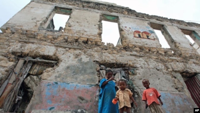 Internally displaced children stand outside a decrepit building they are using as a temporary home in the Hodan district of Somalia's capital Mogadishu, September 6, 2011.