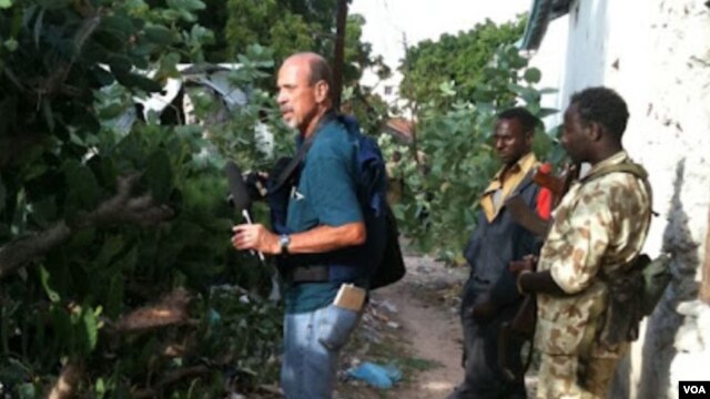 VOA's Peter Heinlein investigates wreckage from the "Black Hawk Down" incident near Mogadishu, Somalia, Aug. 13, 2011. (VOA Photo/G. Joselow)