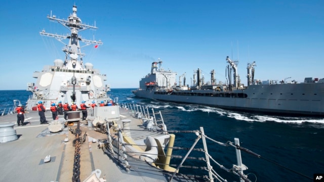 FILE - Guided-missile destroyer USS Bulkeley participates in a replenishment-at-sea with fleet replenishment oiler USNS John Lenthall in the Gulf of Oman. Iranian naval vessels conducted rocket tests last week near the USS Harry S. Truman aircraft carrier