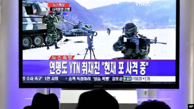 South Koreans watch a live TV breaking news about South Korea's live fire artillery at Seoul train station in Seoul, 20 Dec 2010