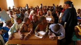 Children listen to a school teacher after the reopening of Mahamane Fondogoumo elementary school in the town center of Timbuktu, Mali, February 1, 2013.