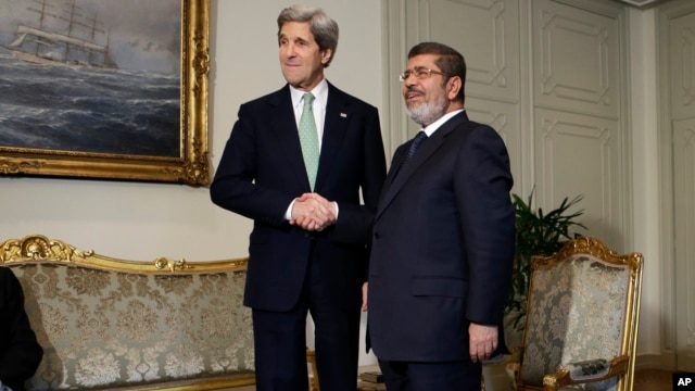 U.S. Secretary of State John Kerry shakes hands with Egyptian President Mohamed Morsi at the Presidential Palace in Cairo, Egypt, March 3, 2013.