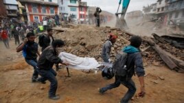 Nhân viên cứu hộ khiêng thi thể một nạn nhân trên cáng ra khỏi một tòa nhà bị sập sau trận động đất mạnh ở Kathmandu, Nepal, ngày 25/4/2015.