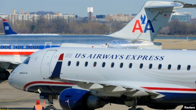 A US Airways Express plane departs from a gate past an American Airlines plane at the Ronald Reagan Washington National Airport in Arlington County, Virginia, February 10, 2013.