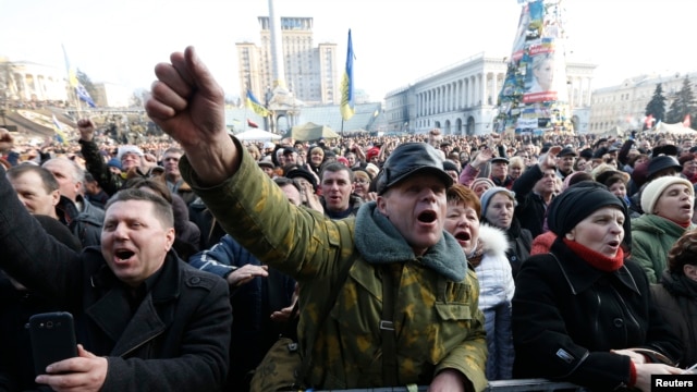 People cheer as they listen to speeches in front of a statue in Independence Square in Kyiv, Feb. 21, 2014. 