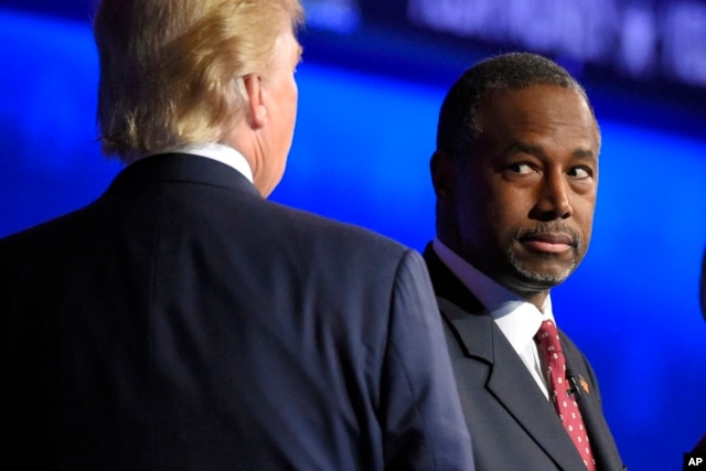 Ben Carson watches as Donald Trump takes the stage during the CNBC Republican presidential debate at the University of Colorado, Oct. 28, 2015.