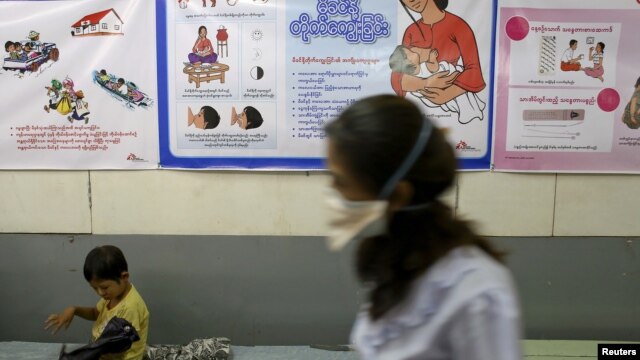 A nurse walks past as a child sitting at Medecins Sans Frontieres Holland's clinic in Rangoon, March 3, 2014.