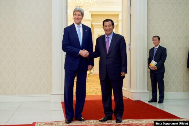 U.S. Secretary of State John Kerry poses for photographers with Cambodian Prime Minister Hun Sen before a bilateral meeting on Jan. 26, 2016, at the Peace Palace in Phnom Penh, Cambodia.