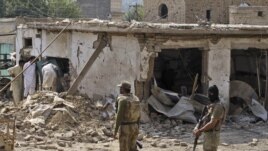 Pakistani men check the damage caused by a car bomb explosion at the site in the town of Darra Adam Khel in the troubled Khyber Pakhtunkhwa province bordering Afghanistan, October 13, 2012. 