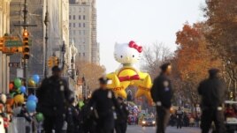 Cảnh sát đi bộ dọc theo Central Park West, phía sau là quả bóng bay khổng lồ Hello Kitty sẵn sàng cho cuộc diễu hành, ngày 22/11/2012.