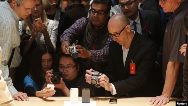 Miembros de los medios de comunicación fotografían el nuevo iPhone 5 en su presentación.