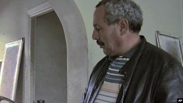 A Tunisian examines a lampshade in one of the mansions owned by family of ousted long-time Tunisian dictator President Zine El Abidine Ben Ali, January 2011