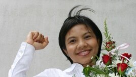 FILE - Thai media activist Supinya Klangnarong celebrates at the criminal court in Bangkok, March 15, 2006.