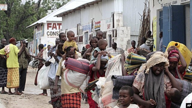 Displaced people carry their belongings as they flee from Badbaado settlement after two groups of Somalia government soldiers clashed inside the camp in the capital Mogadishu, August 5, 2011