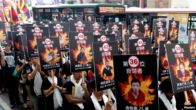 Activists display portraits of people who killed themselves by self-immolation take part in a rally to support Tibet, Taipei, Taiwan, March 10, 2013.