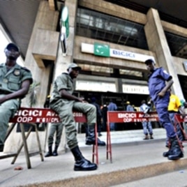 Security contain clients standing outside the headquarters of the Bicici bank as they came to withdraw money in Abidjan, March 3, 2011