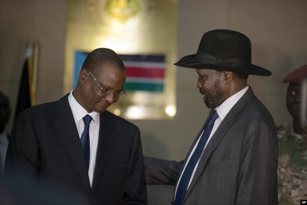 South Sudan's First Vice President Taban Deng Gai, left, speaks with President Salva Kiir, right, after Taban was sworn in, replacing opposition leader Riek Machar, at the presidential palace in Juba, South Sudan, Tuesday, July 26, 2016.