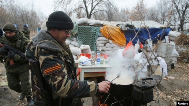 Phiến quân đòi ly khai thân Nga nấu thức ăn bên cạnh một trạm kiểm soát ở Donetsk, ngày 18/11/2014.