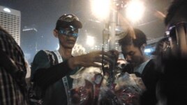 Seorang pedagang berjualan topeng di malam pergantian tahun 2012-2013 di seputar bundaran Hotel Indonesia, Jakarta (VOA/Iris Gera)