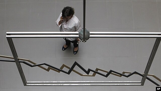 An employee of the Athens Stock Exchange speaks on her cell phone in Athens, August 8, 2011.