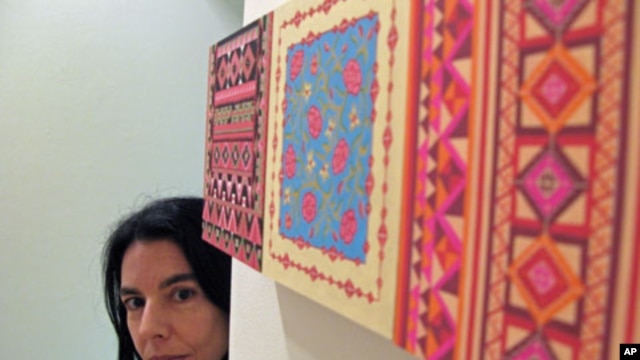 Artist Helen Zughaib takes a peek around her piece 'Another Wall,' June 2011