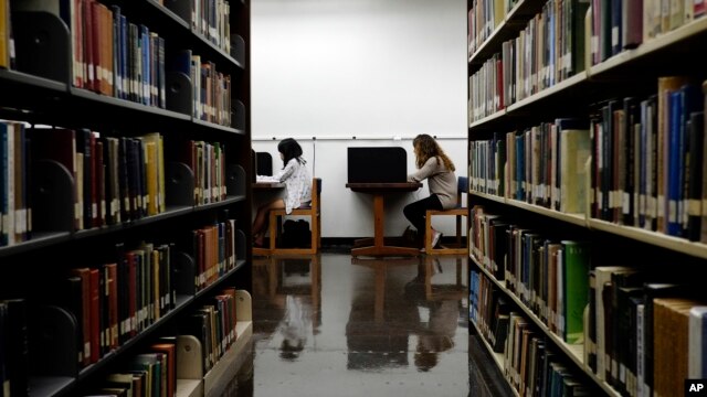 FILE - Students are seen studying in a library on the campus of California State University in Long Beach, California, Oct. 19, 2012. After factoring in age, gender, education and economic status, researchers found that readers lived two years longer than non-readers.