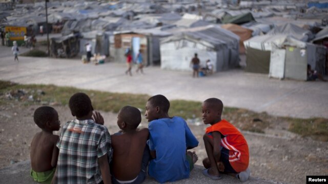 A group of boys sit on the rooftop of a home damaged by the 2010 earthquake, across from a camp where they now reside, Port-au-Prince, Haiti, January 9, 2013. 