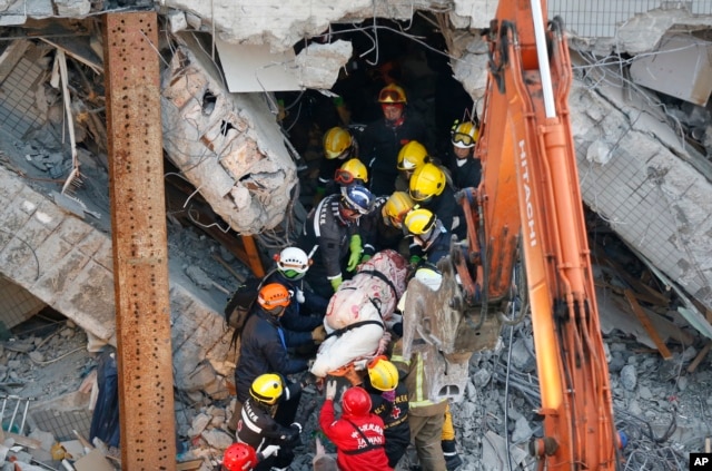FILE - Emergency rescuers remove a body found in a collapsed building from an earthquake in Tainan, Taiwan, Feb. 7, 2016.