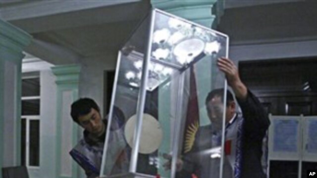 Members of local electoral committee empty a ballot box at a polling station in Osh, southern Kyrgyzsta, Sunday, 10 Oct. 2010.