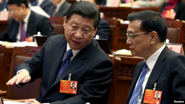 China's Communist Party Chief Xi Jinping speaks to Vice Premier Li Keqiang, presidium of the first session of the 12th National People's Congress, Beijing, March 4, 2013.
