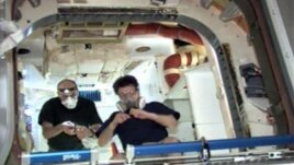 Space station astronaut Donald Pettit (L) and another astronaut work inside the Dragon spacecraft after entering for the first time, a day after Dragon's heralded arrival as the world's first commercial supply ship, May 26, 2012.